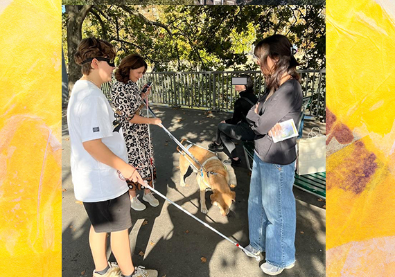 Tag des Weissen Stockes Aktion in Zürich - Blindversuche. Eine Gruppe von vier Menschen steht zusammen, inkl. einem Blindenführhund, heller Labrador. Zwei der Personen haben einen Weissen Stock dabe, eine davon eine Dunkelbrille an.