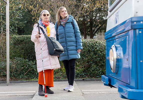 TWS 2026_06_blinde Frau wartet mit Begleiterin auf das Tram